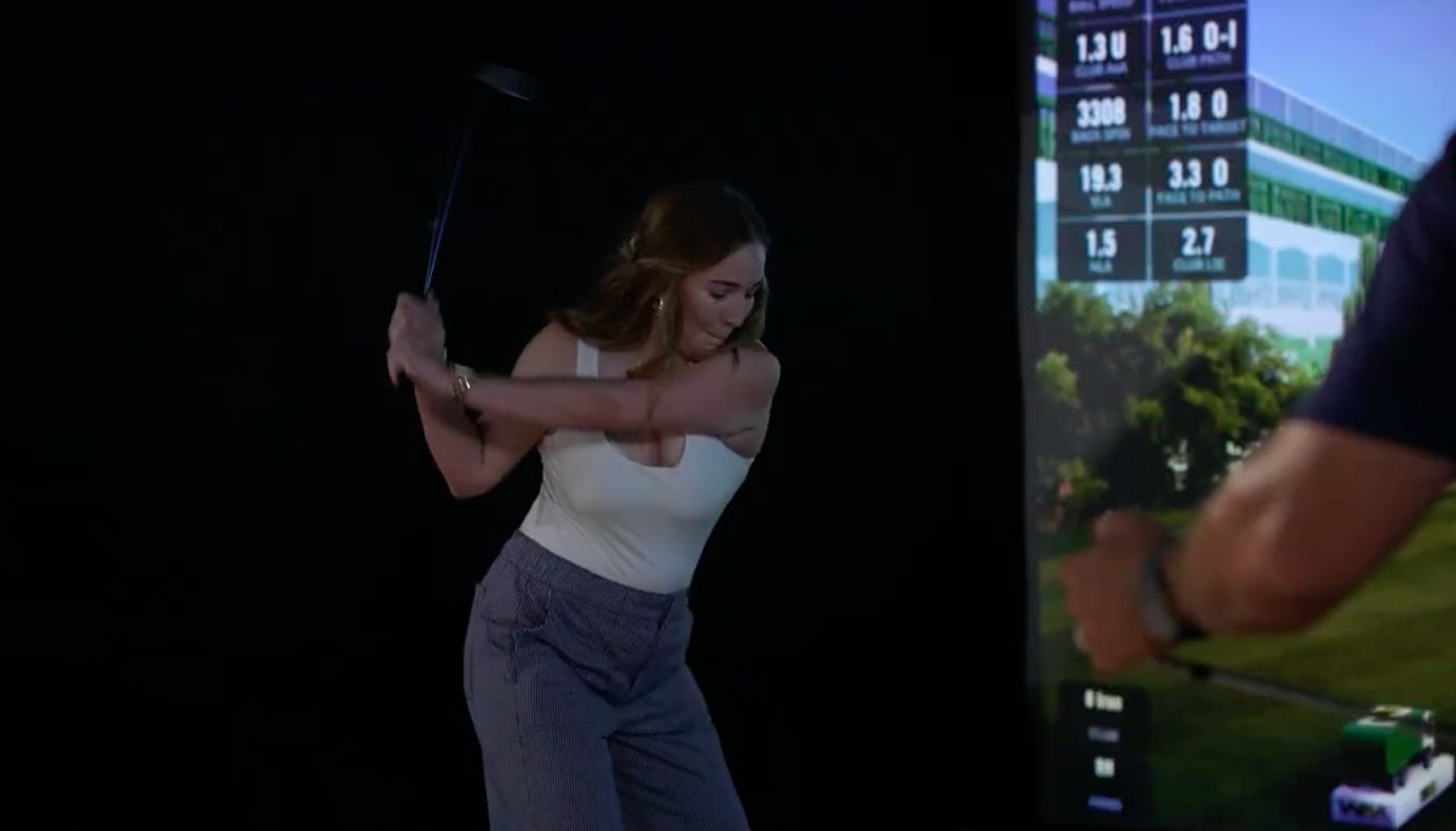 Guest taking a golf swing during a mobile simulator experience