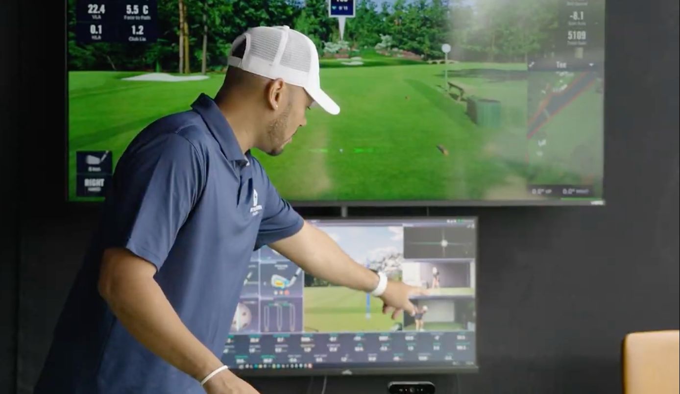 On The Green Studios event attendant reviewing golf swing and shot data