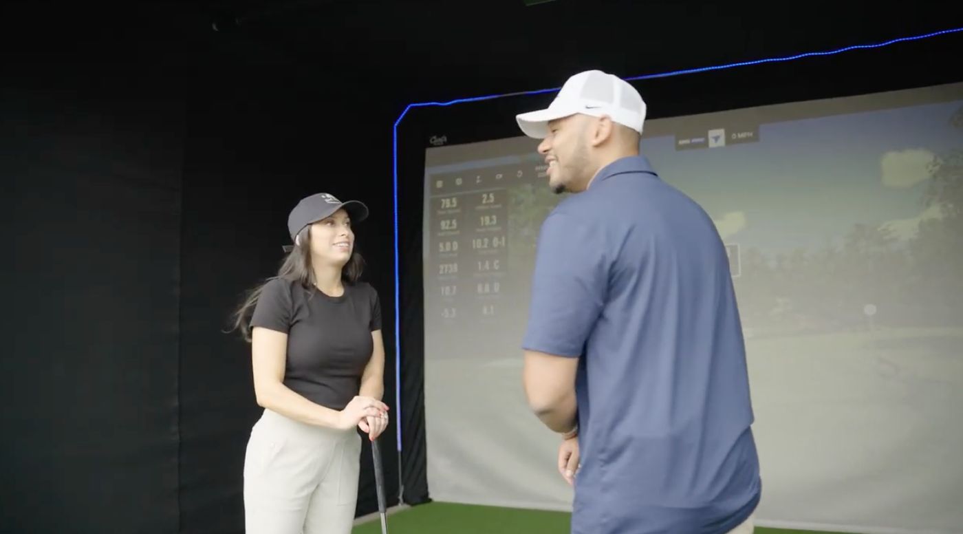 On The Green Studios team member assisting a guest during a simulator event
