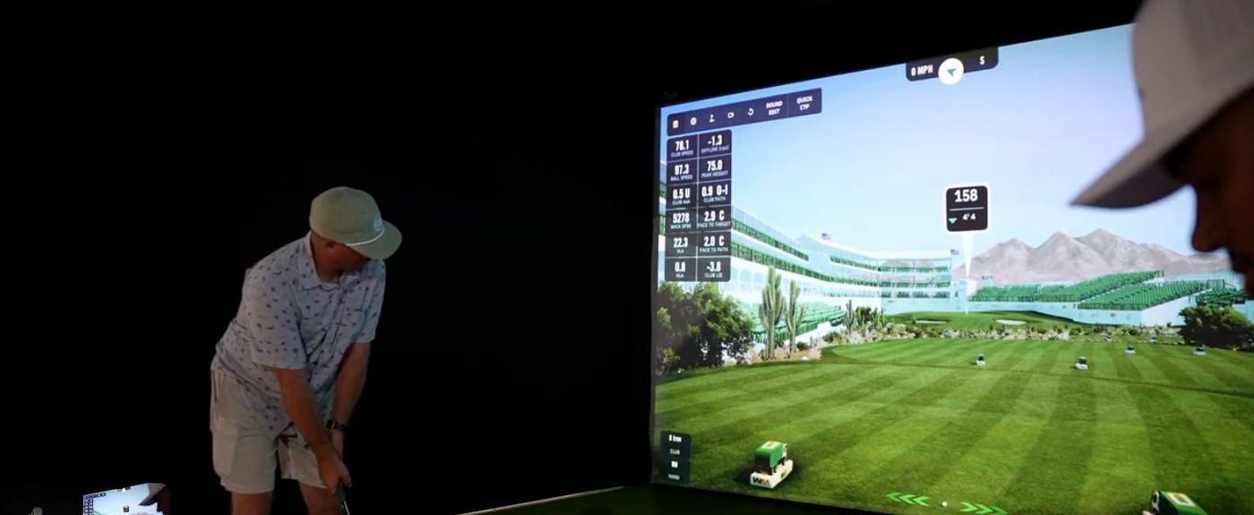 Event guest preparing to hit inside the On The Green Studios mobile golf simulator