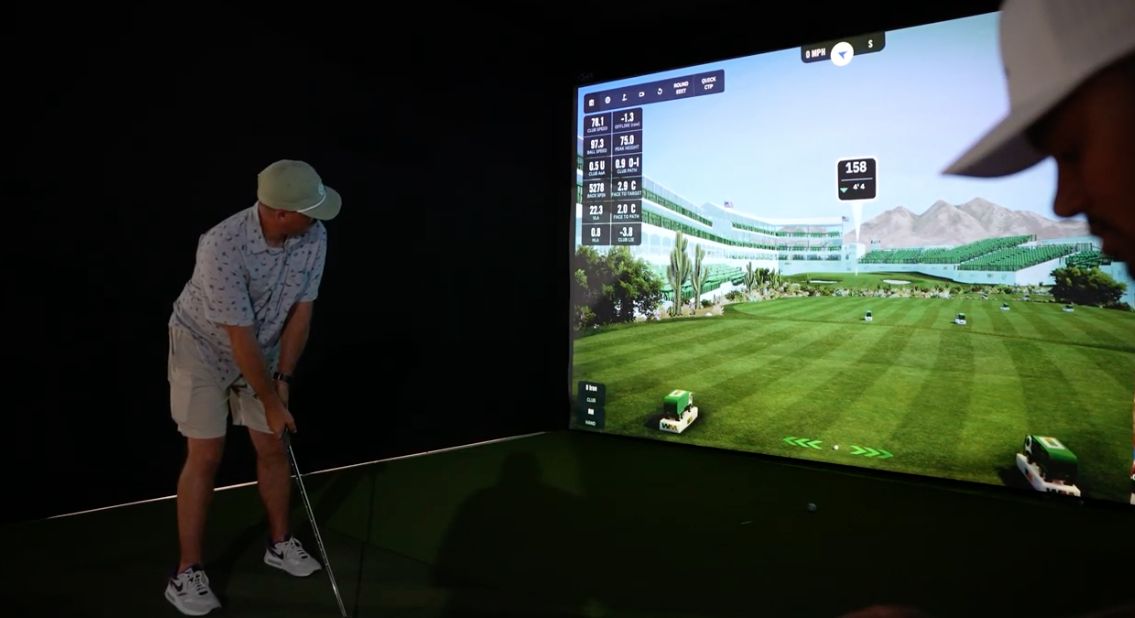 Golfer addressing the ball during an interactive mobile simulator event